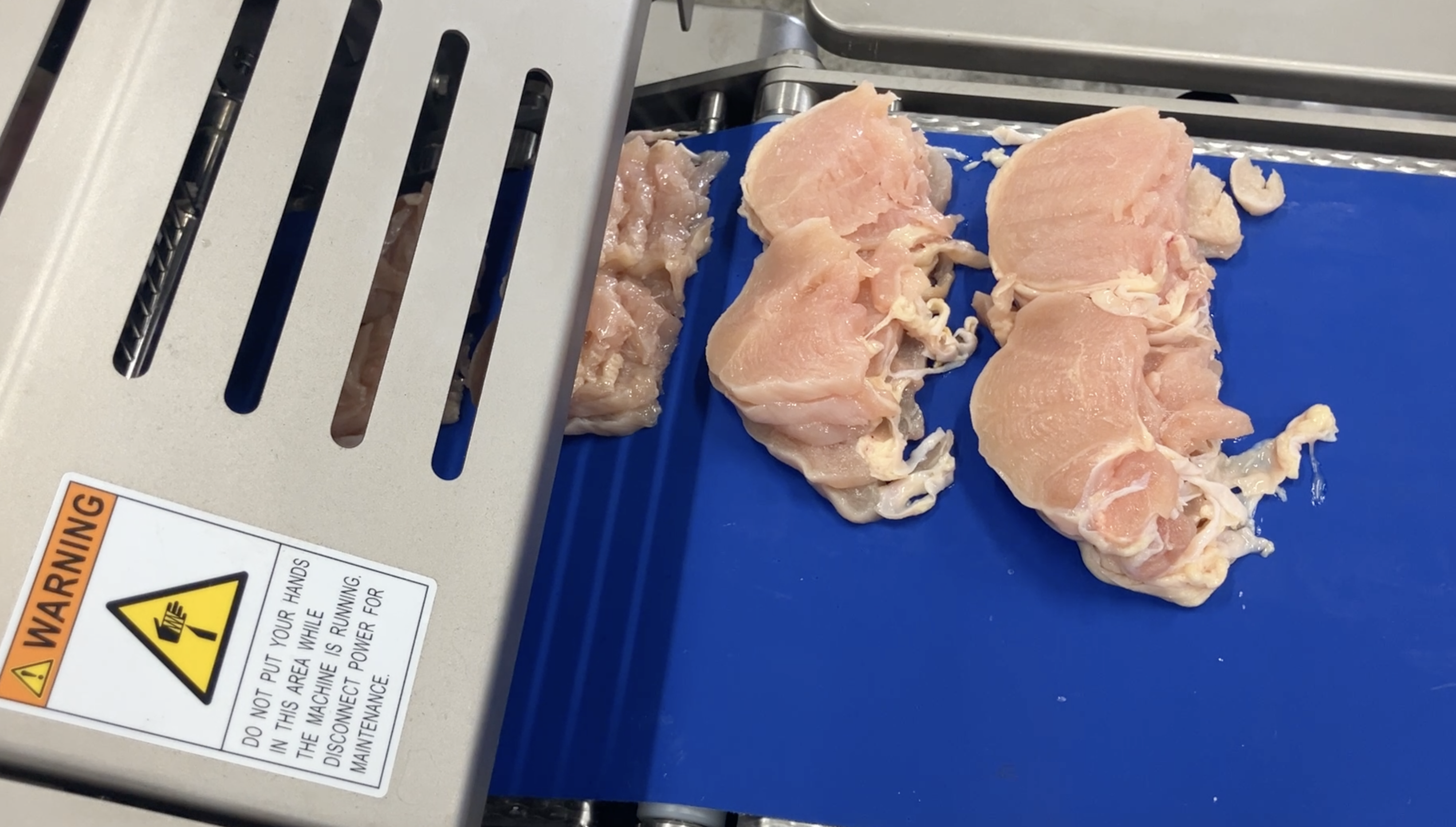 Raw chicken breast being sliced on the NCI line, Case 01 raw chicken