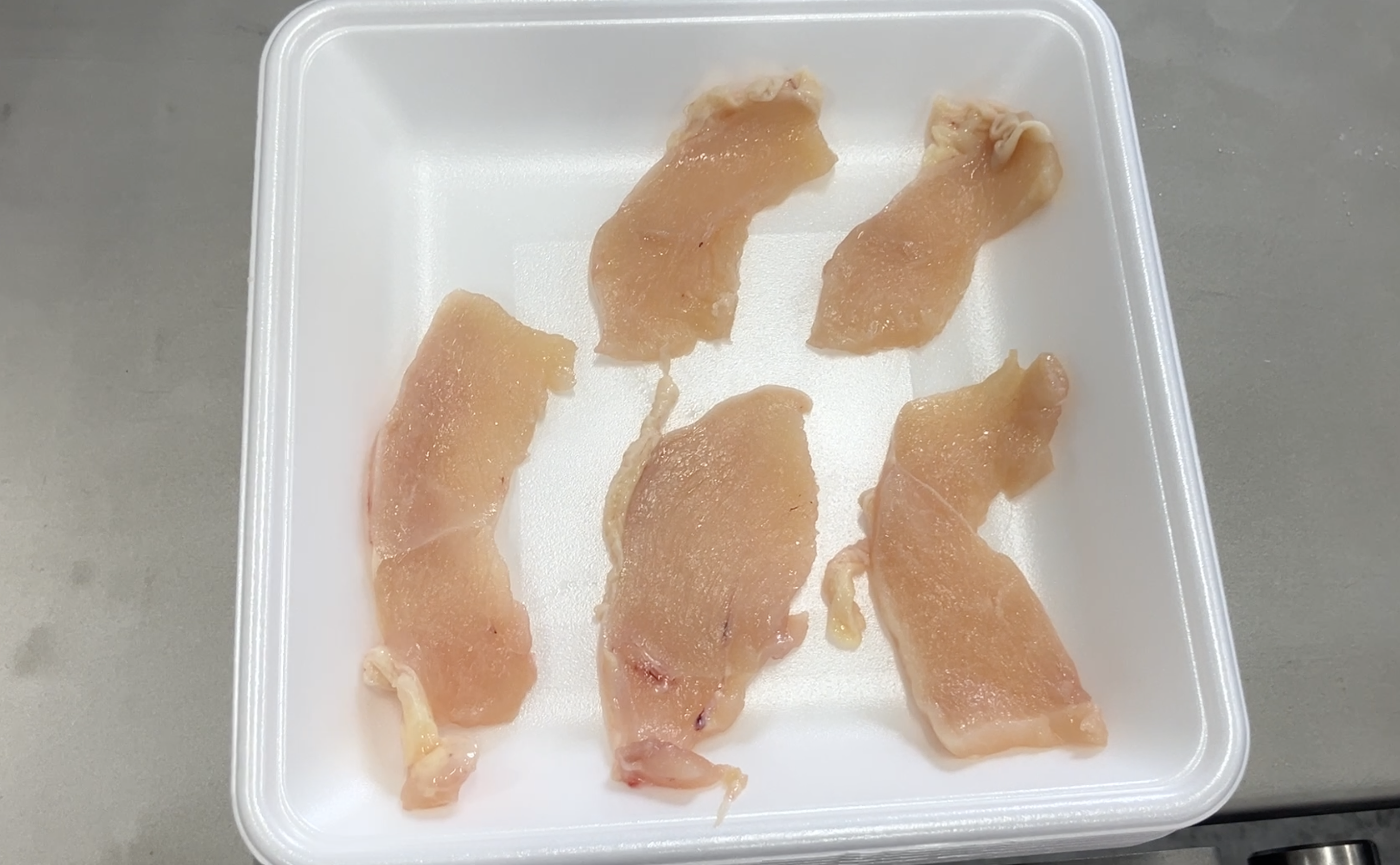 Close-up detail of the Case 01 raw chicken slices